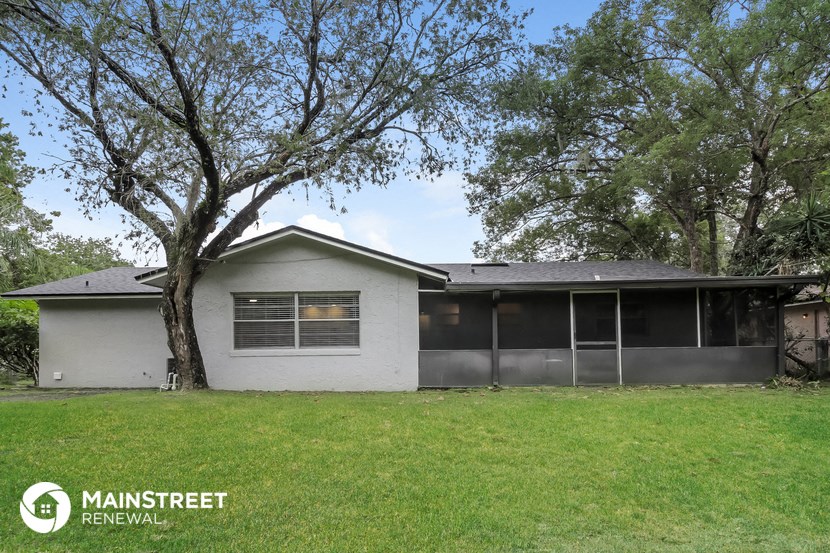 a small white house with a tree in front of it