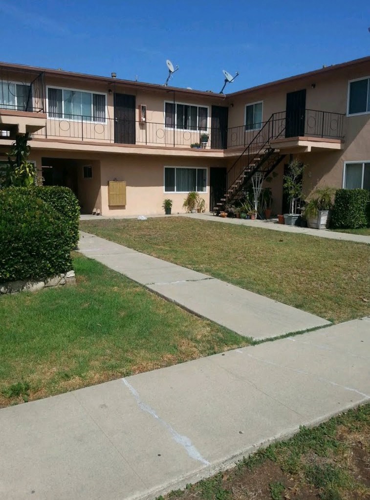 Apartment complex with a walkway in front.