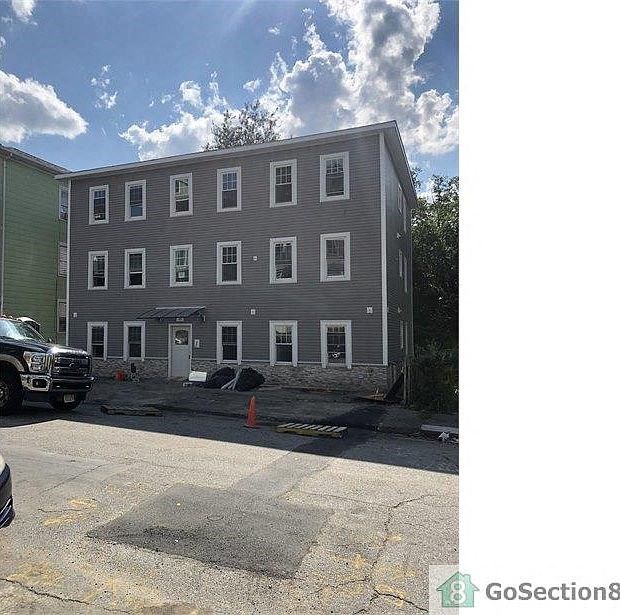 A building with a grey facade and a white door is under construction.
