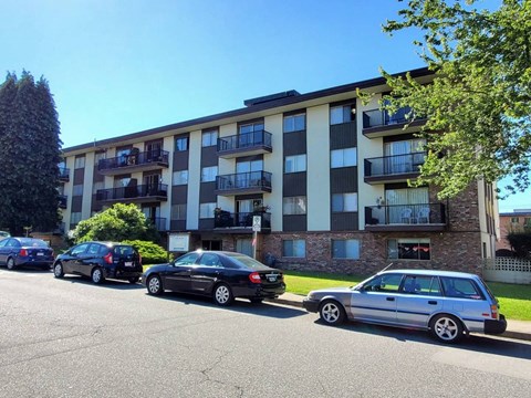 an apartment building with cars parked in front of it