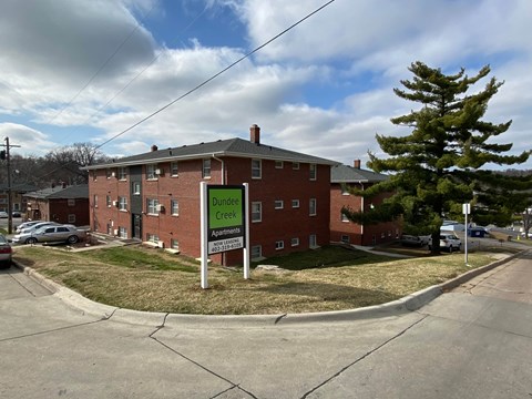 Dunmore Creek Apartments is a brick building with a green sign in front.