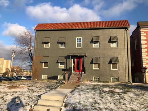 a building with a red door and steps in the snow