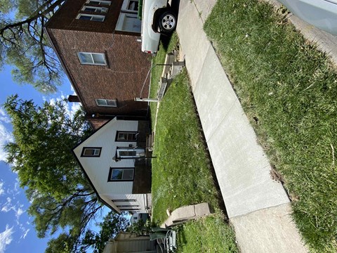 a car is parked on the sidewalk in front of a house
