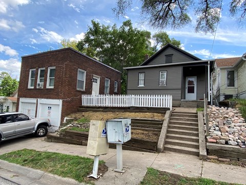 a house and a truck parked in front of a sidewalk