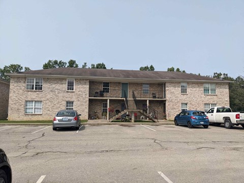 a large brick building with cars parked in front of it