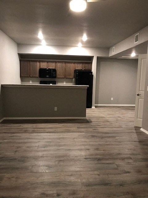 an empty living room with a kitchen and