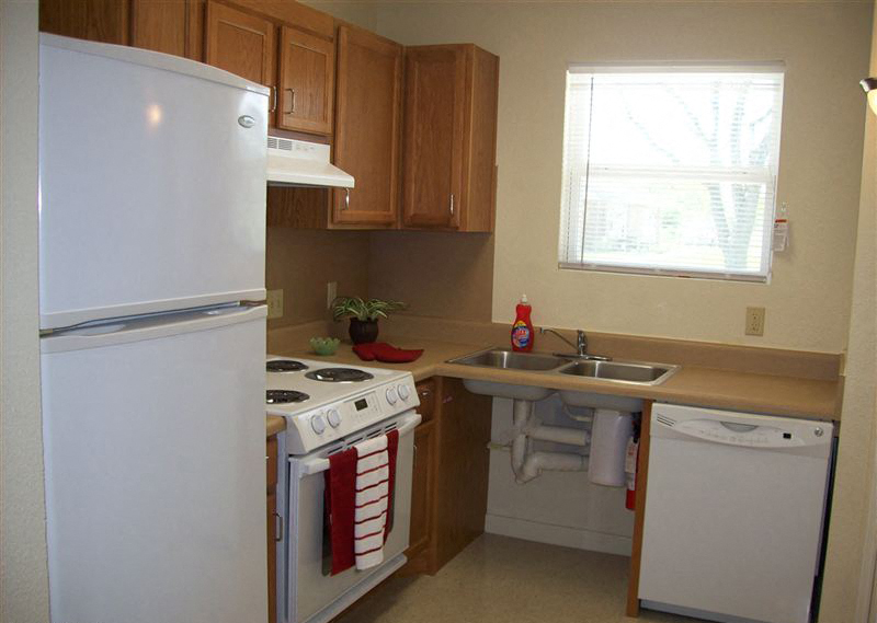 a small kitchen with a stove refrigerator and sink