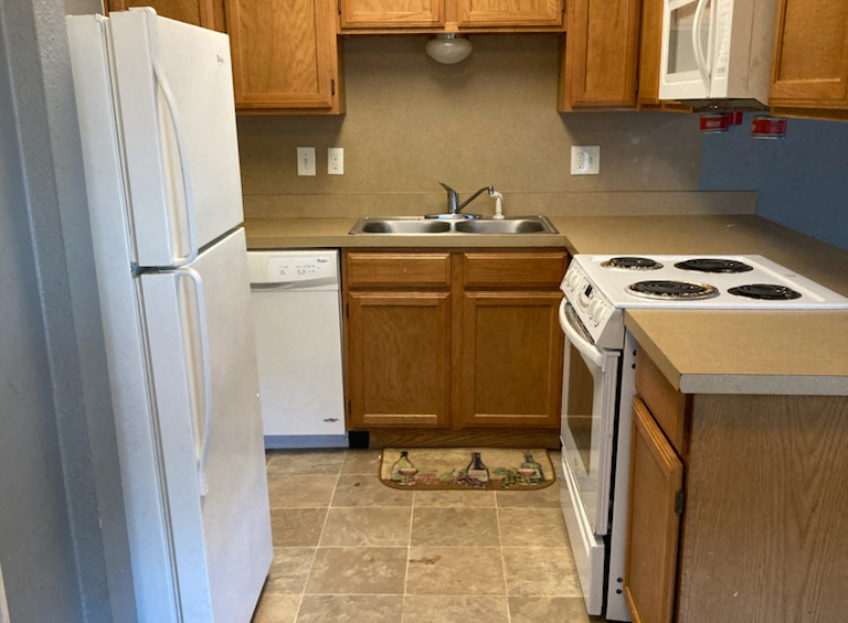 a kitchen with a stove refrigerator and a sink