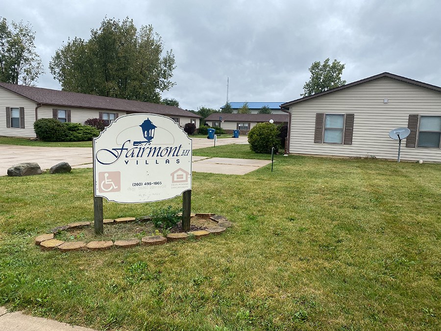 a neighborhood sign in front of a house