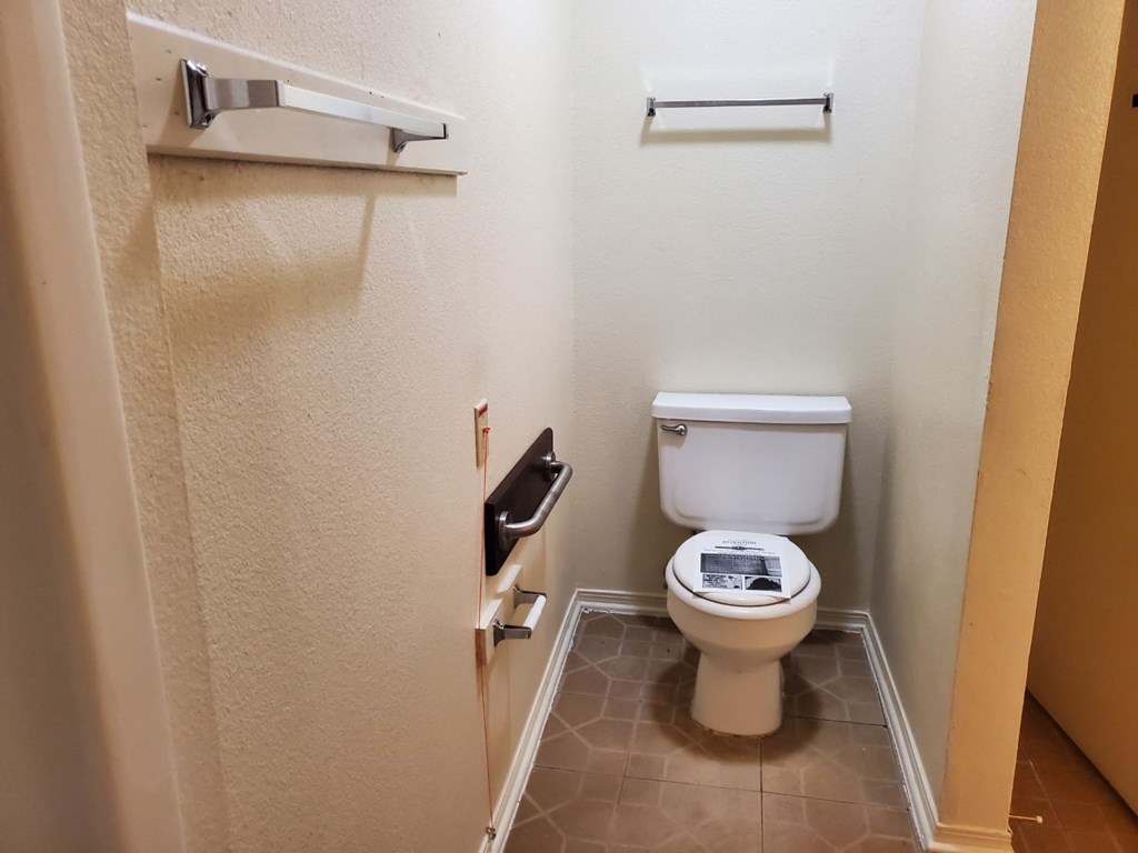a bathroom with a toilet and a roll of toilet paper
