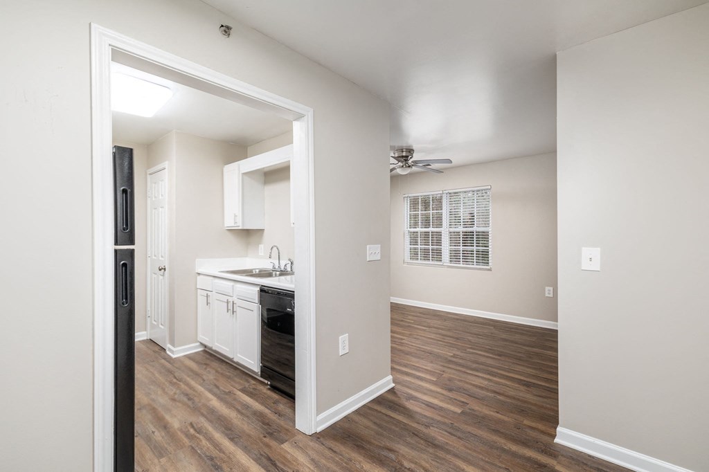 an open kitchen and living room with a hard wood floor