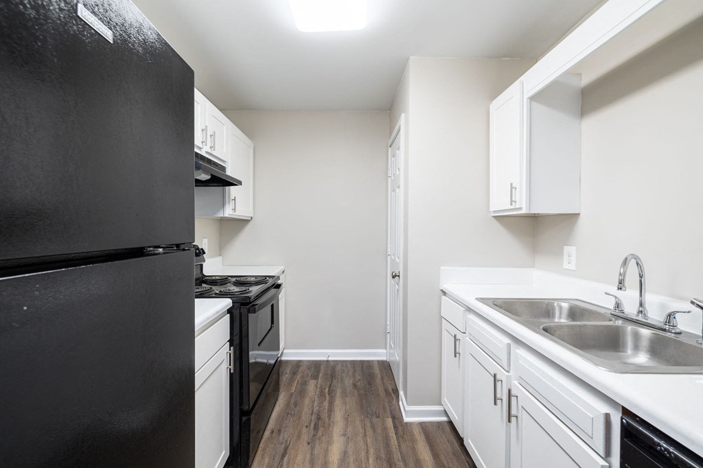 a kitchen with white cabinets and black appliances and a black refrigerator