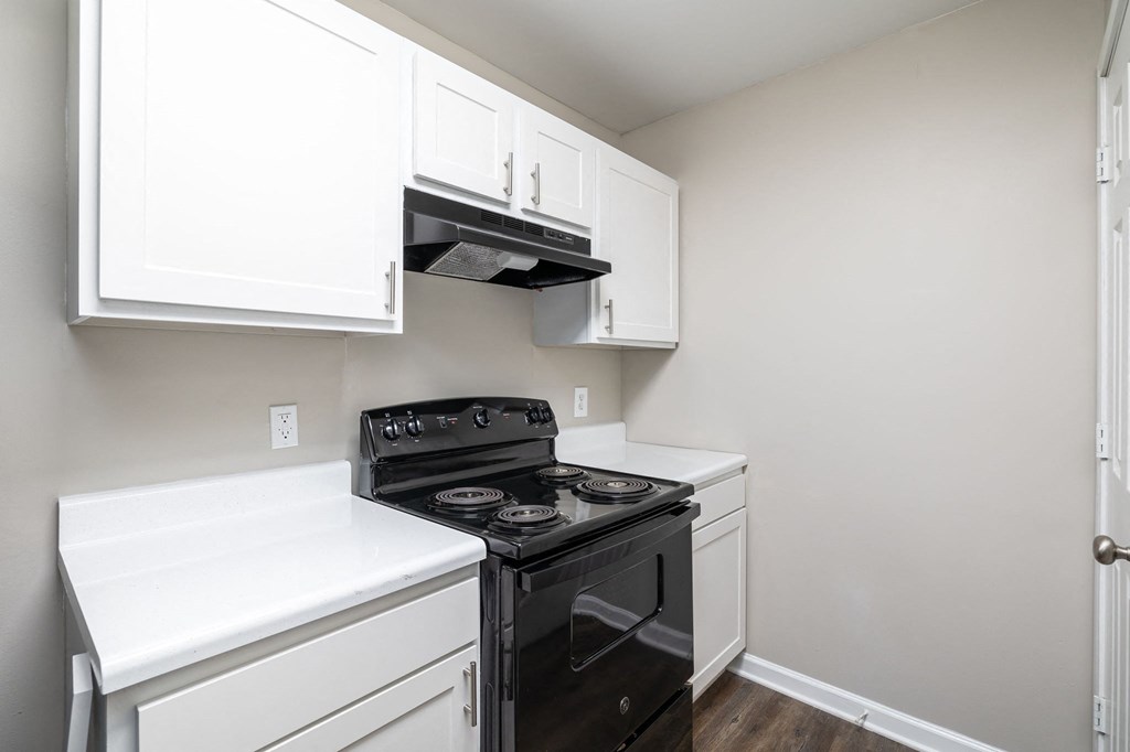 a kitchen with white cabinets and a black stove and oven