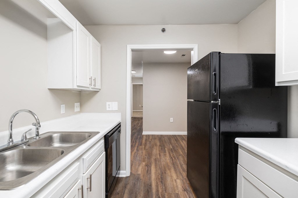 a kitchen with white cabinets and a black refrigerator