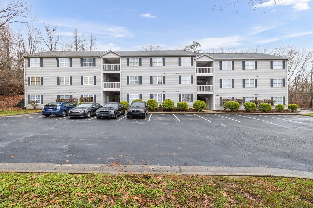 an apartment building with cars parked in front of it