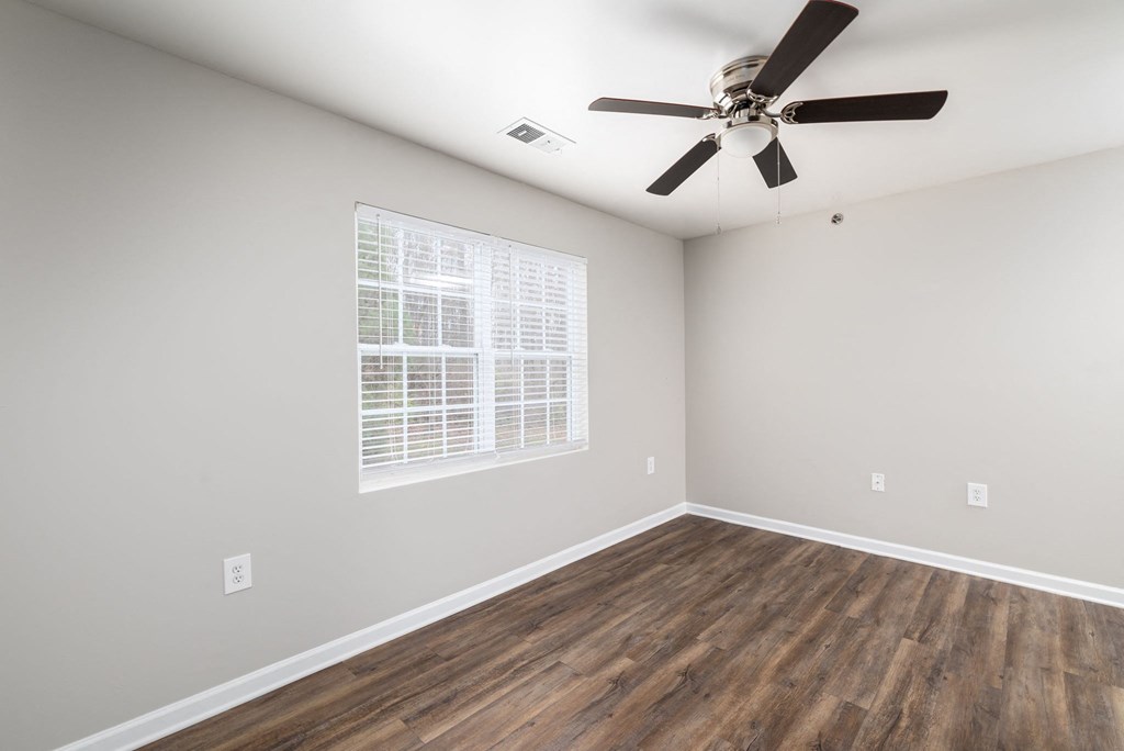 an empty room with a ceiling fan and a window