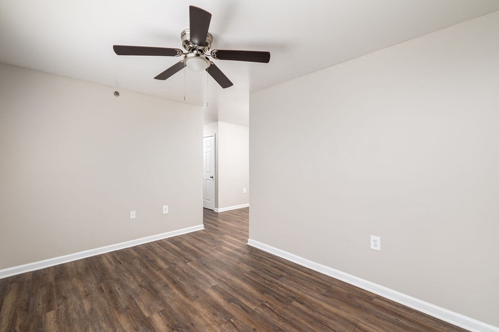 a living room with white walls and a ceiling fan