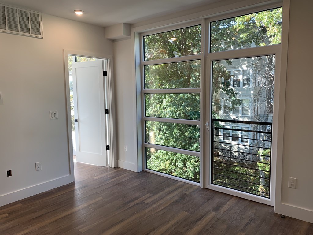 a living room with a large window and a door to a balcony