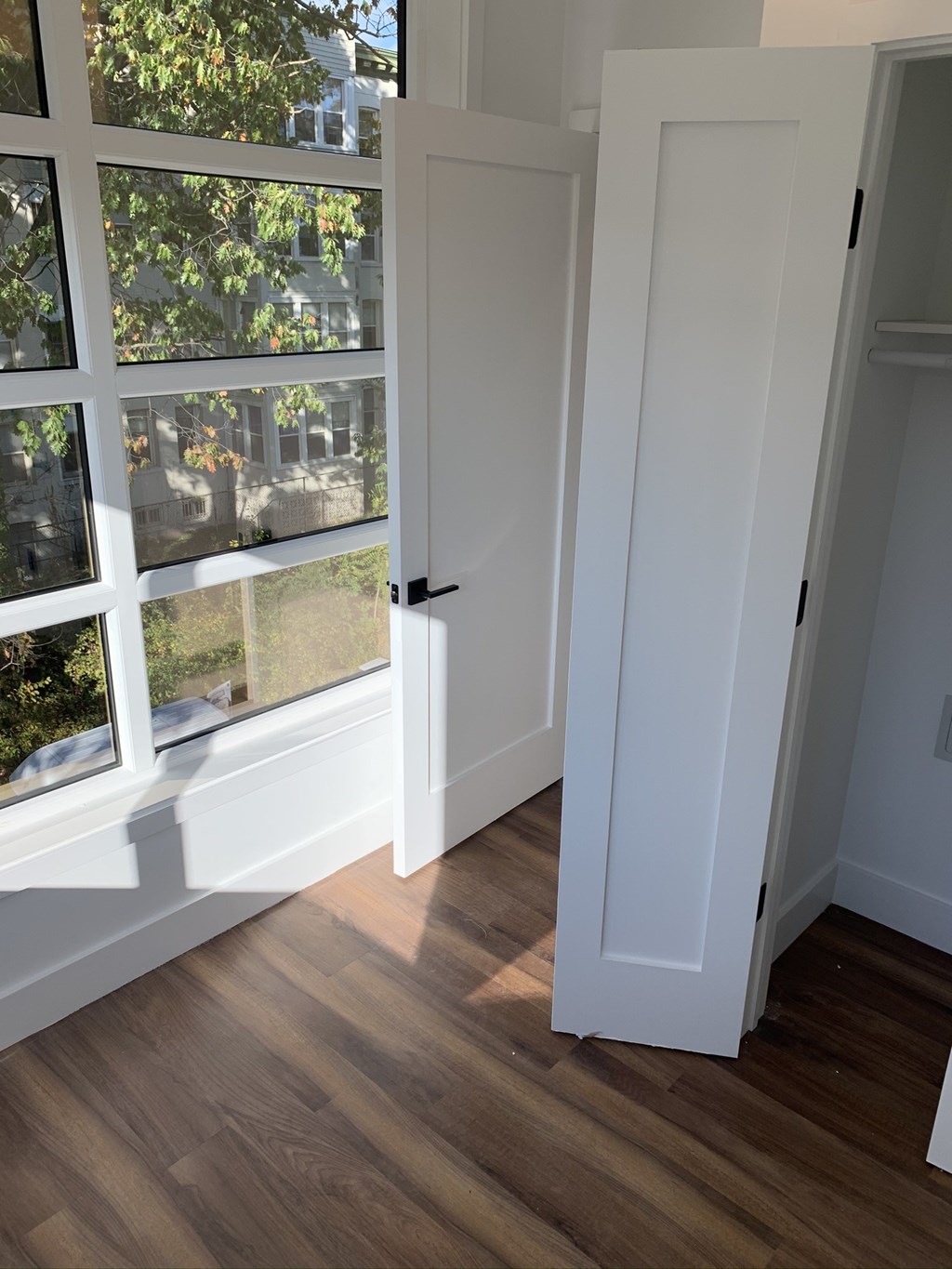 an open white door with a window and a wooden floor