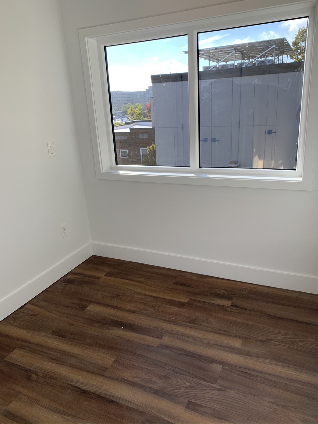 an empty room with wooden floors and a window
