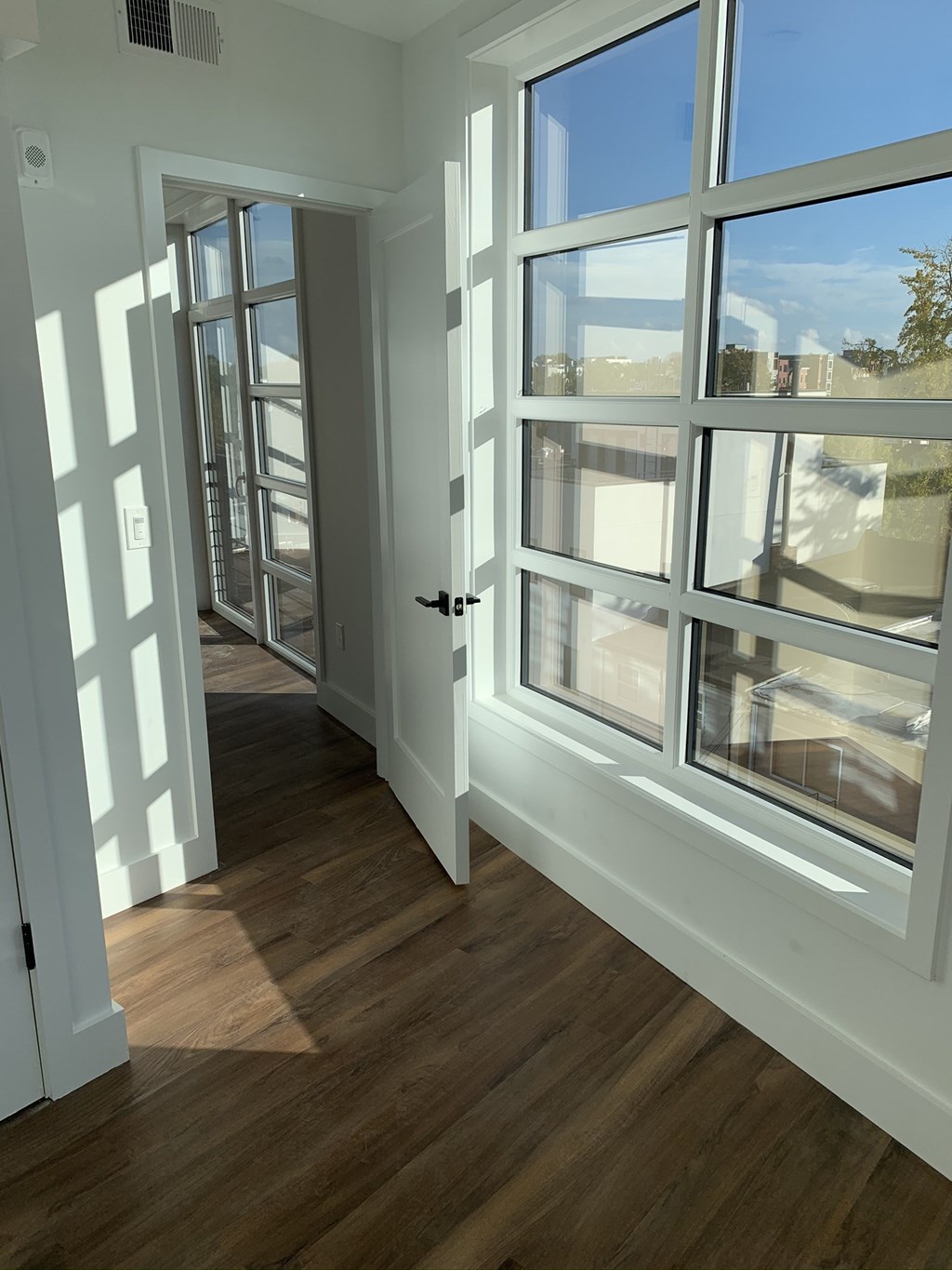 a living room with large windows and a door to a balcony