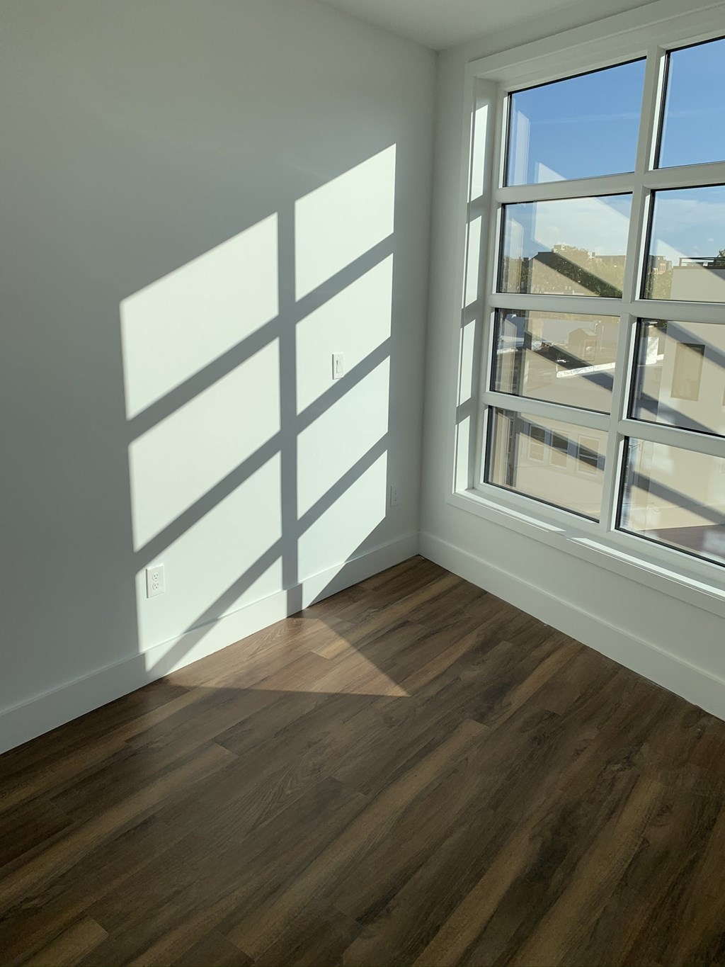 an empty living room with windows and wood flooring