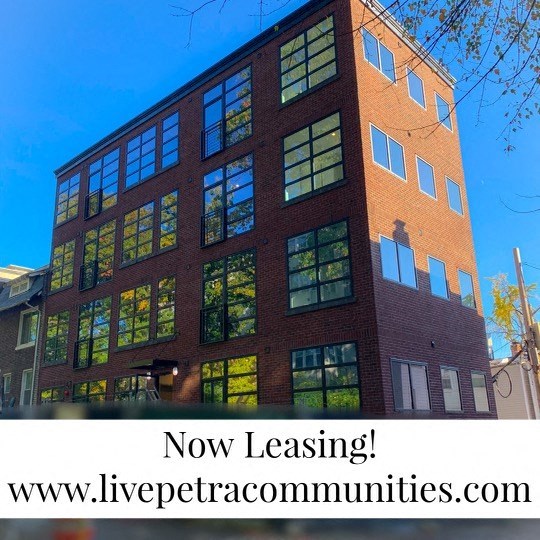 a tall brick building with a blue sky  now leasing