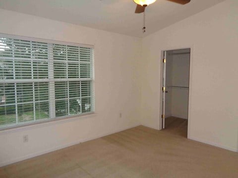 an empty living room with a large window and a door to a closet
