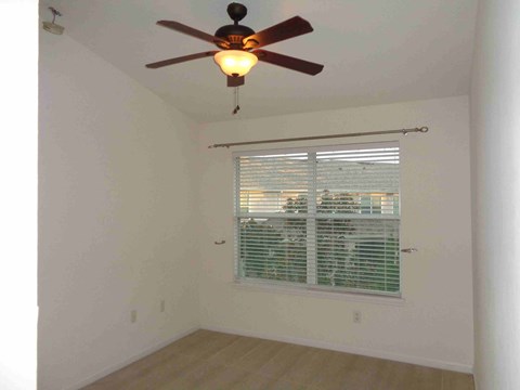 a bedroom with a ceiling fan and a window