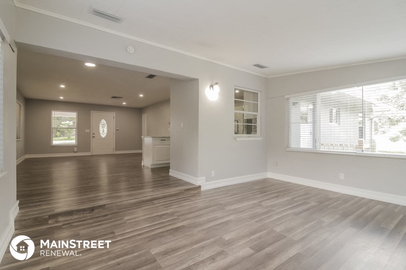 the living room and kitchen of a new home with wood flooring