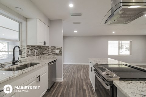a kitchen with marble counter tops and a stove and a sink