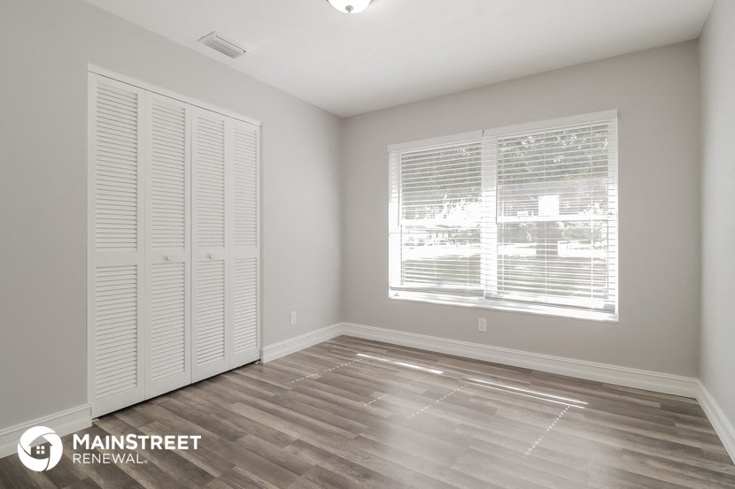 the living room of a new home with wood flooring and a large window