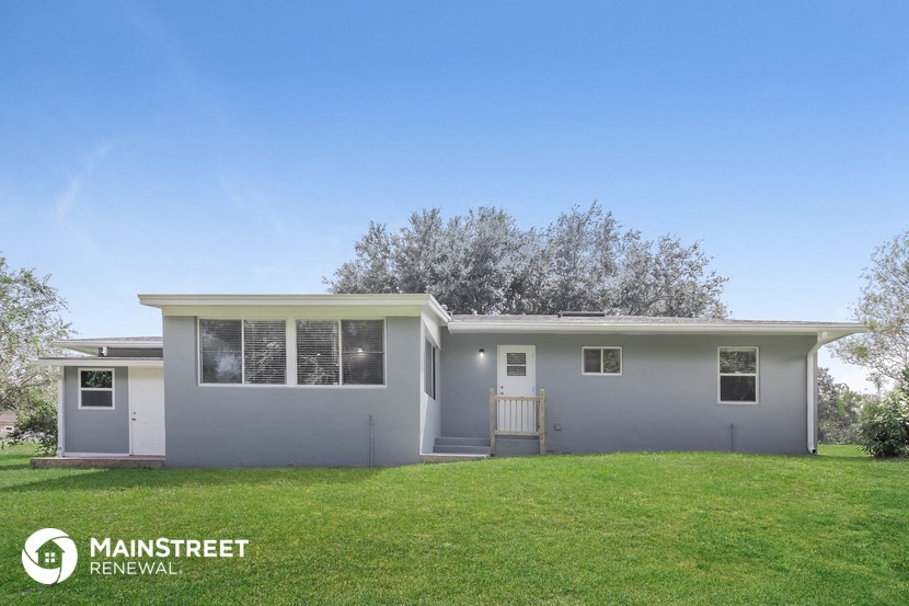 a home with a green lawn and a blue house