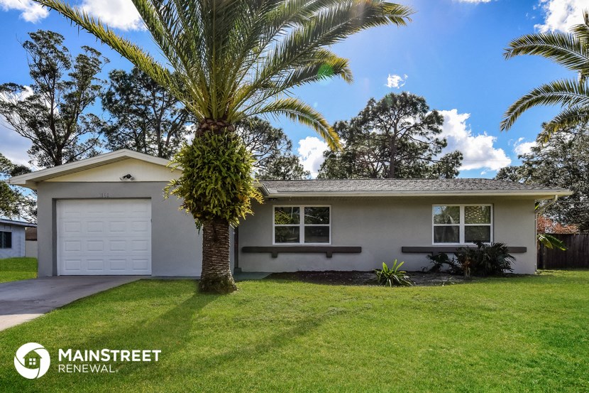 a white house with a palm tree in front of it
