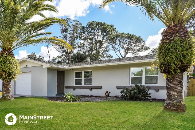 a white house with palm trees in front of it