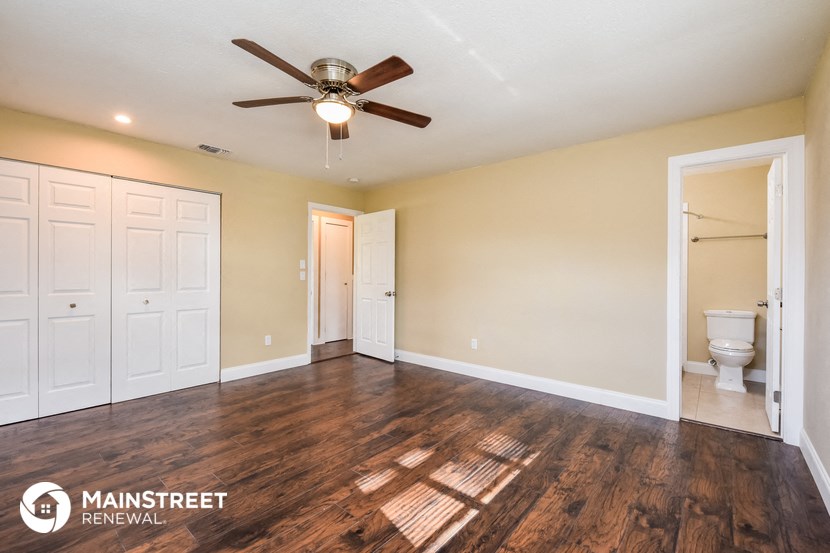 the master bedroom has a large closet and a ceiling fan