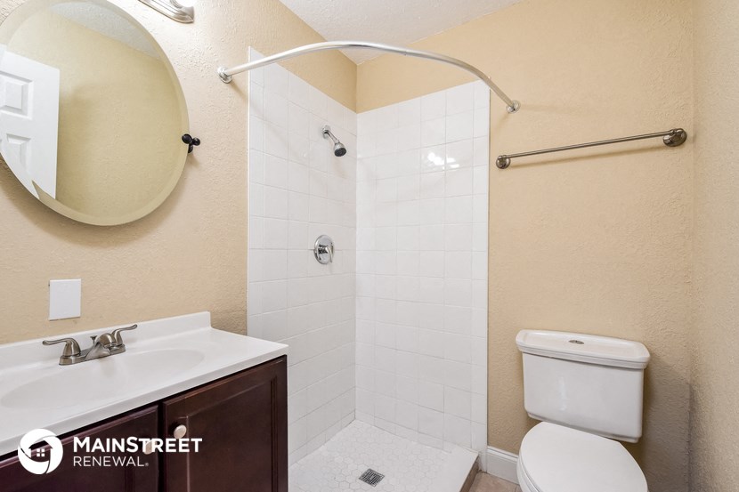 a bathroom with a shower toilet and sink and a mirror