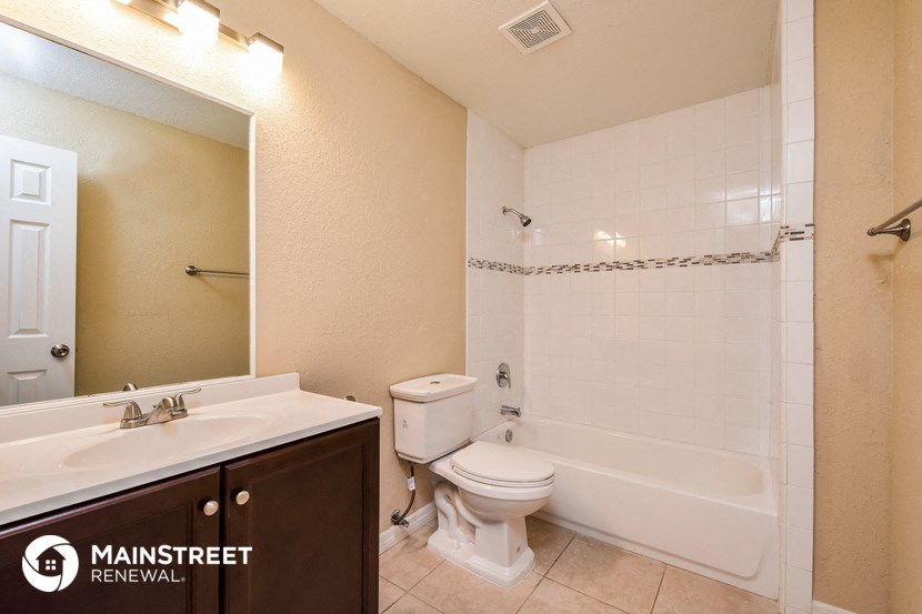 a bathroom with a toilet sink and tub and a mirror