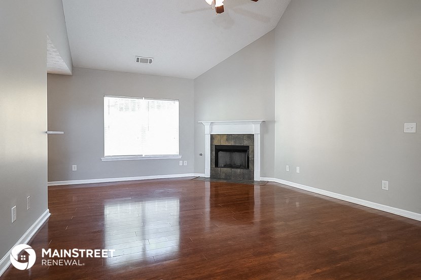 a living room with wood floors and a fireplace
