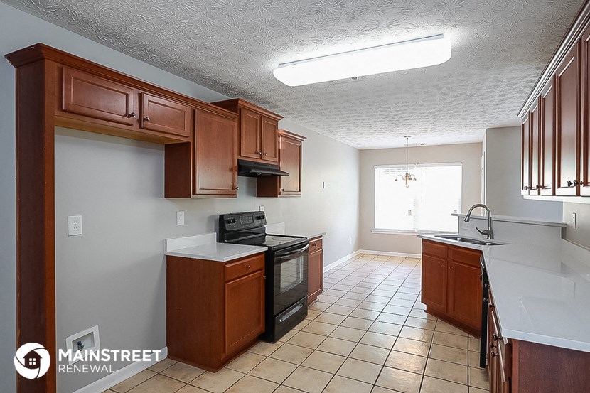 a kitchen with wooden cabinets and a stove and a sink