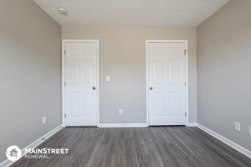 the interior of a room with two doors and wood floors