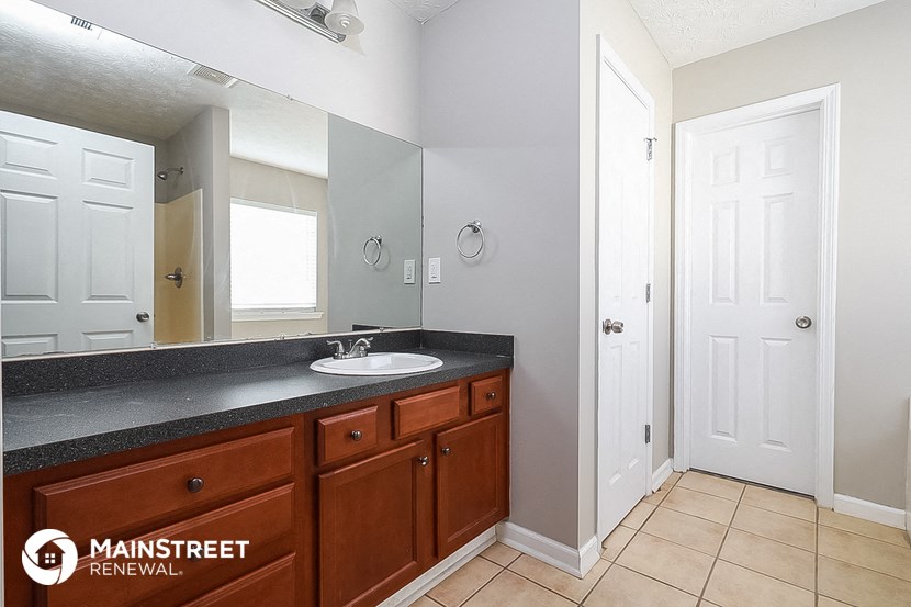 the master bathroom has a large mirror and a sink