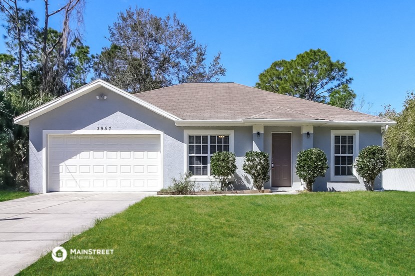 a white house with a garage door and a lawn