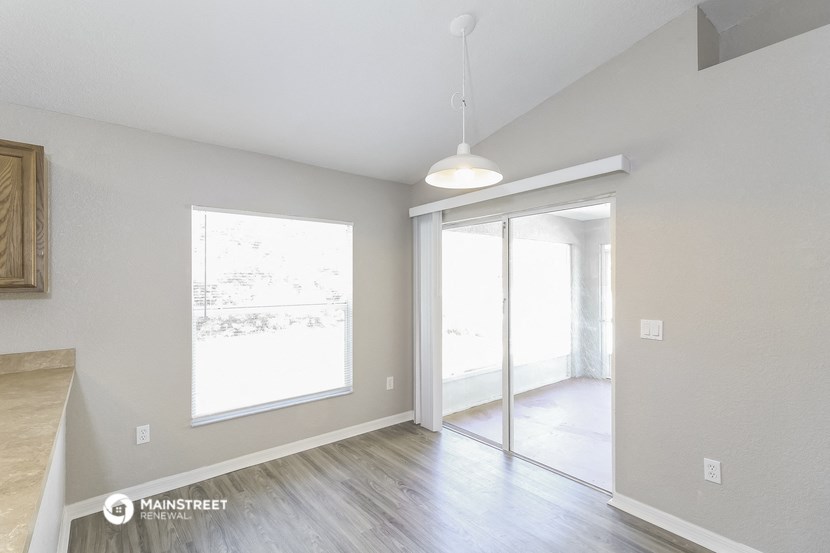 an empty living room with a sliding glass door to a patio