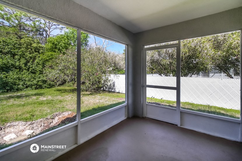 a living room with large windows and a view of a yard