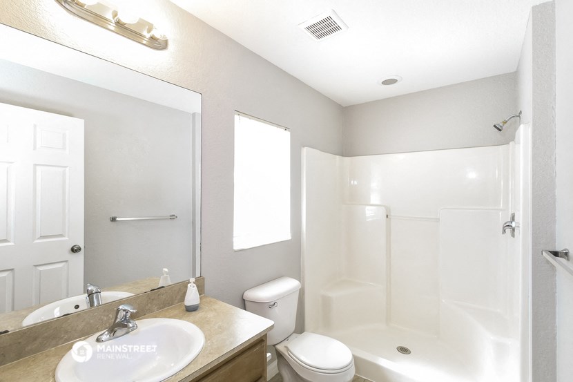 a bathroom with a shower toilet and sink and a mirror