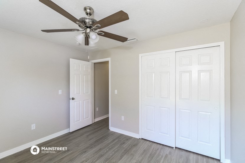 the living room of our studio apartment atrium with ceiling fan and closet