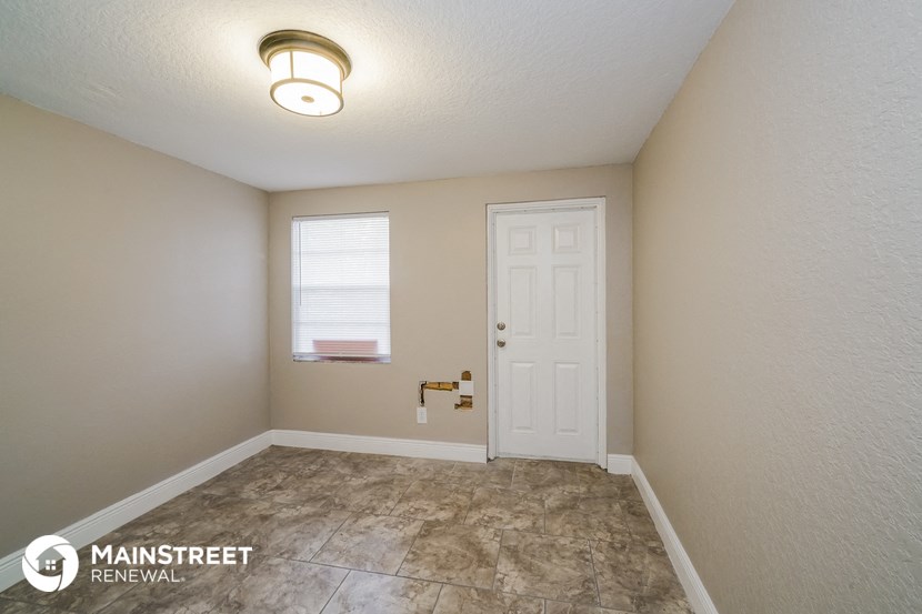 an empty room with a white door and a window