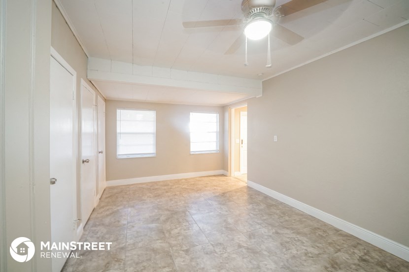 an empty living room with a ceiling fan