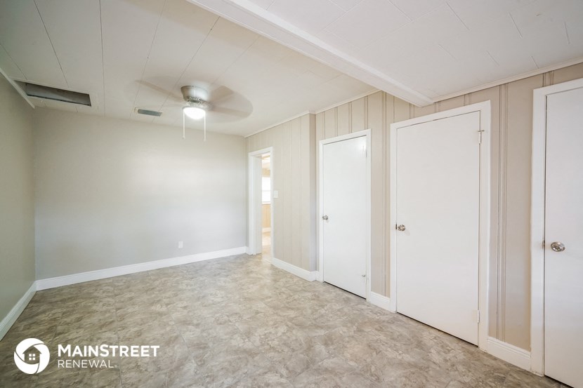 an empty room with three closets and a ceiling fan